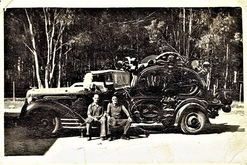 Foto antigua de una carroza fúnebre con dos hombres